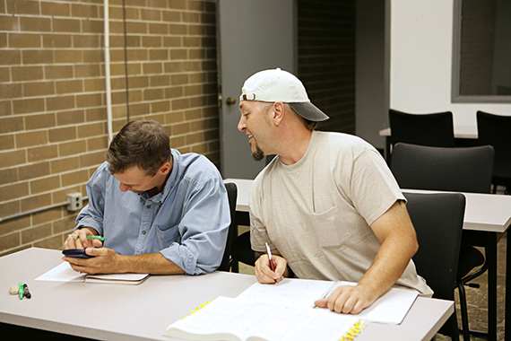 man looking at another mans test answers